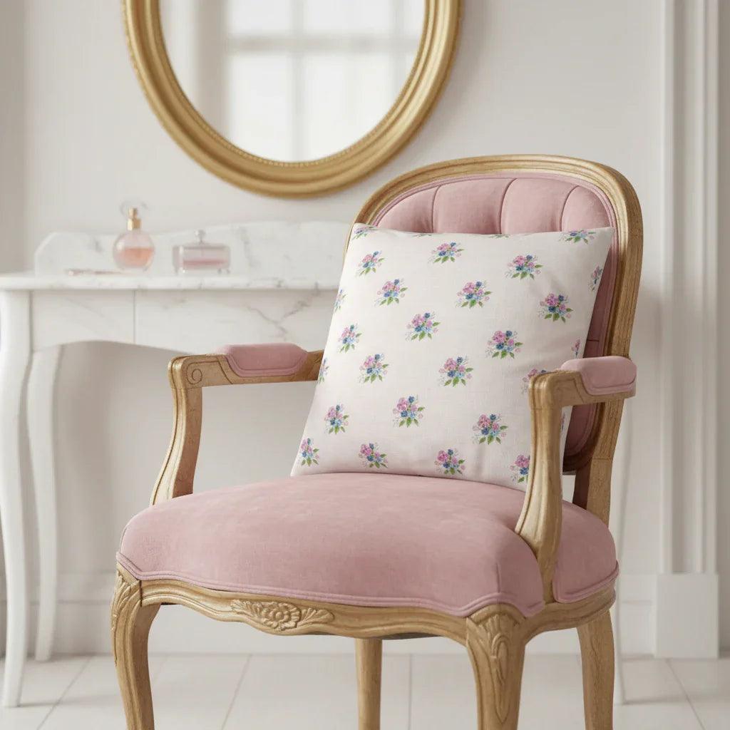 Floral cushion on pink velvet chair with gold frame in elegant room