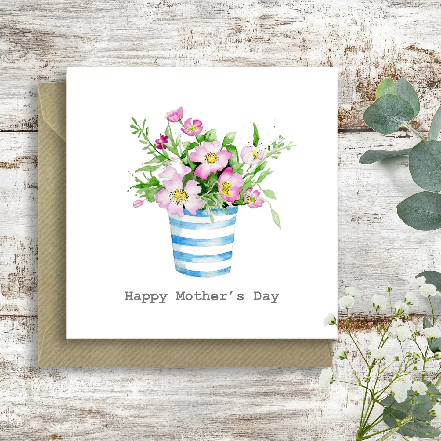 Mother's Day card with watercolor pink flowers in blue striped vase on rustic wood background