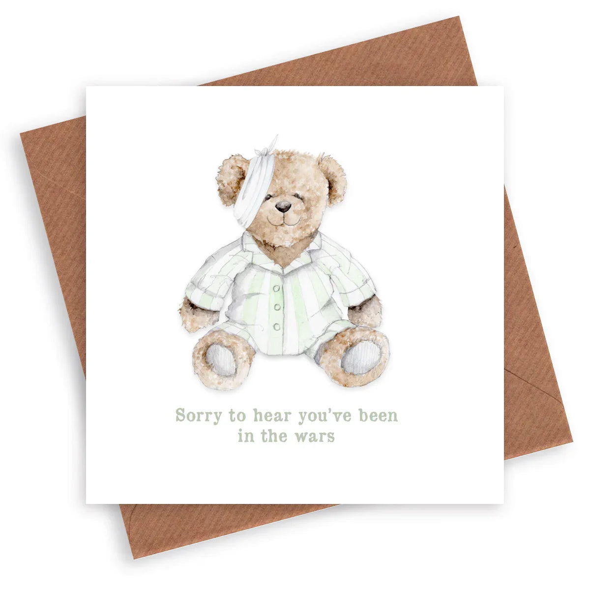 Get well soon card with cute teddy bear in pajamas and bandage, placed on a brown envelope.