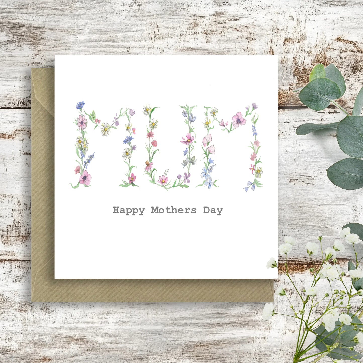 Floral 'MUM' Happy Mothers Day card with envelope on rustic white wood background