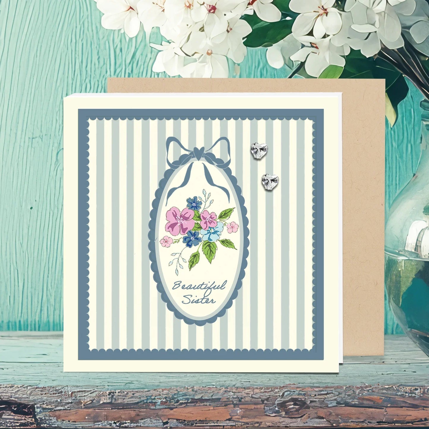 Floral Beautiful Sister greeting card with heart studs, striped border, and flowers.