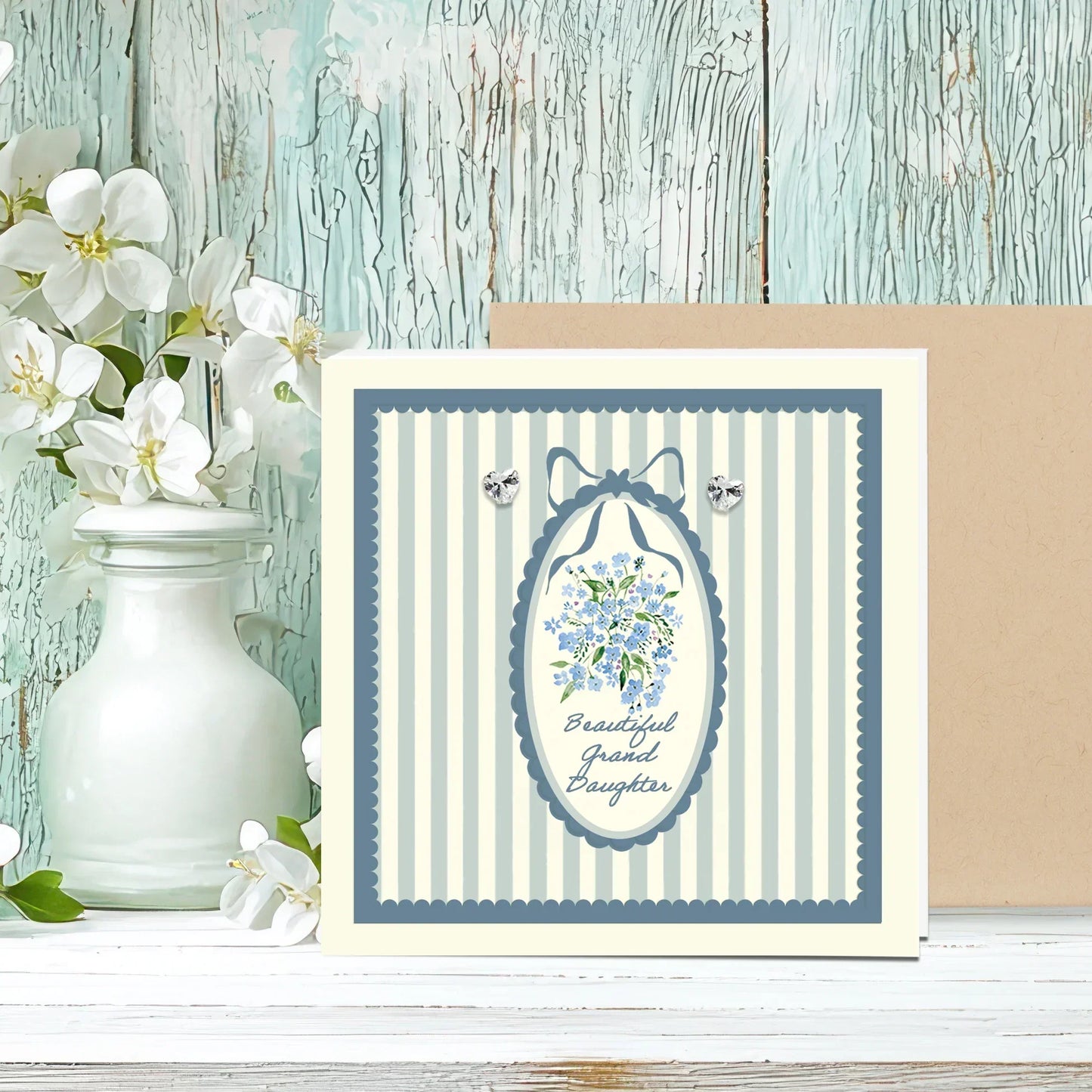 Granddaughter card with blue floral design, striped border, and sparkling heart earrings