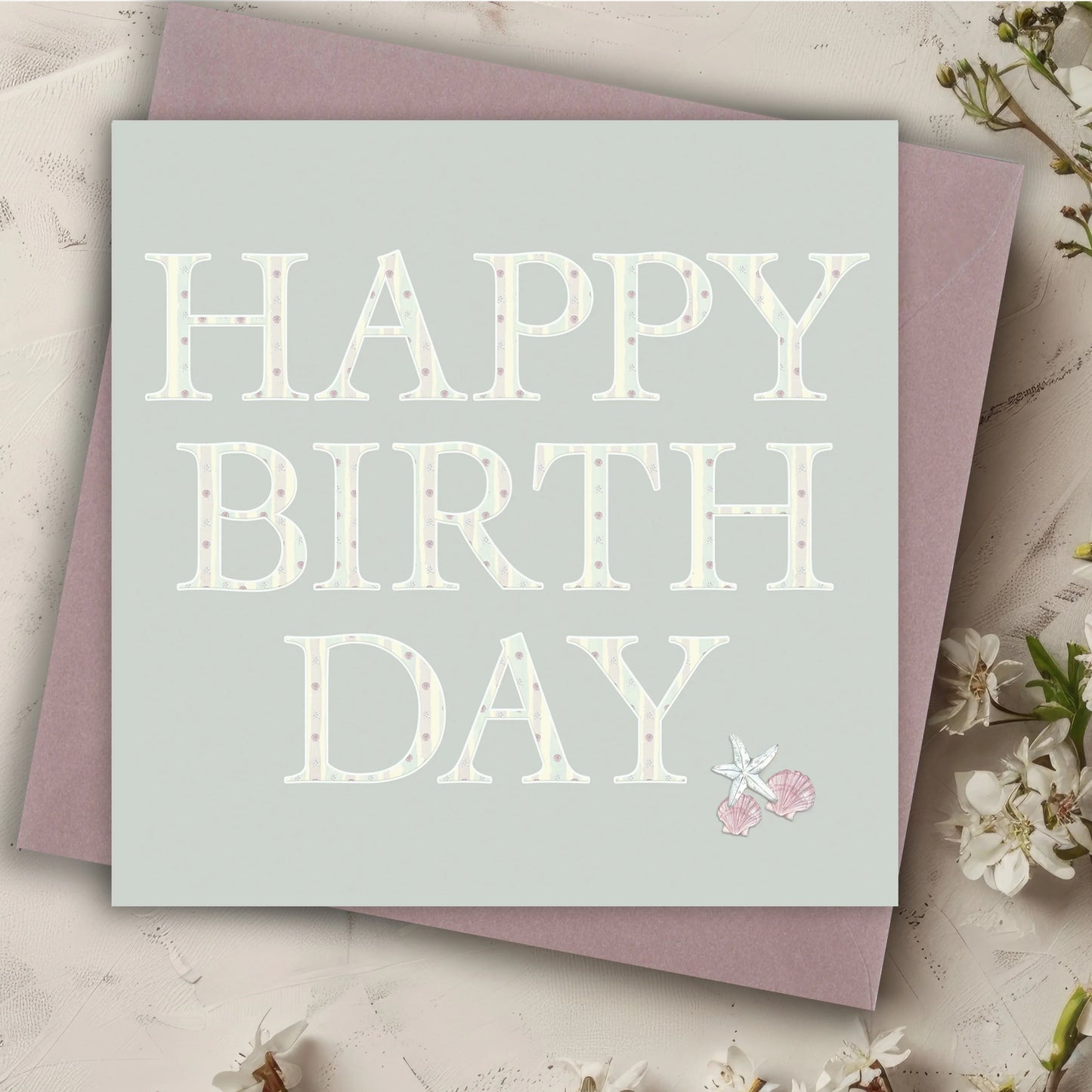 Happy Birthday card with pastel polka dot letters, starfish and seashells, on lilac envelope