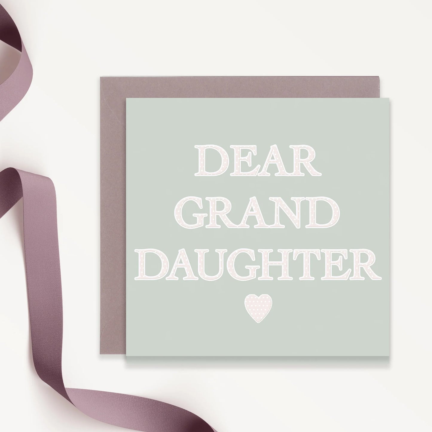 Dear Granddaughter greeting card with heart motif and mauve ribbon, pale green background