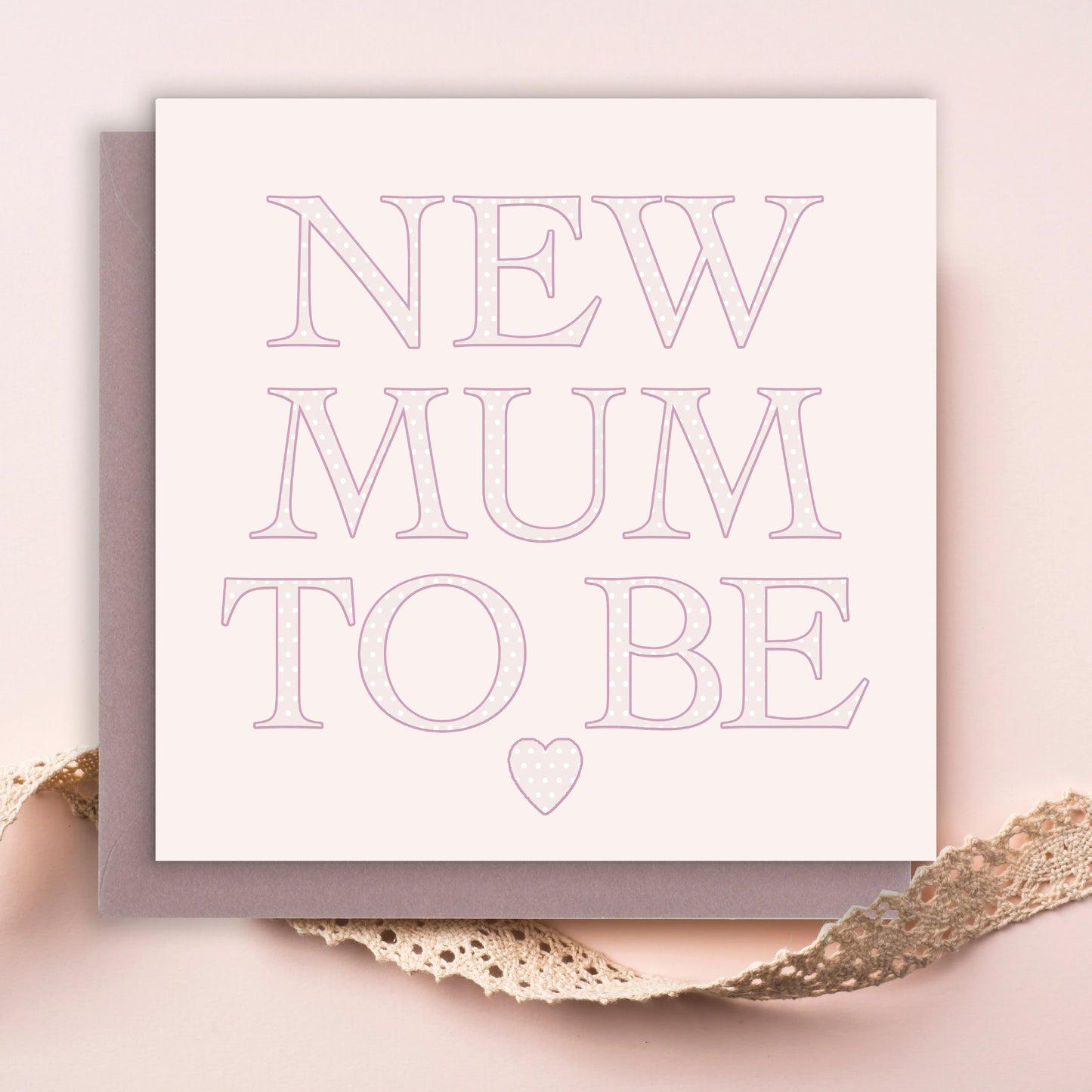 New mum to be greeting card with pink polka dot letters on pastel background, lace ribbon