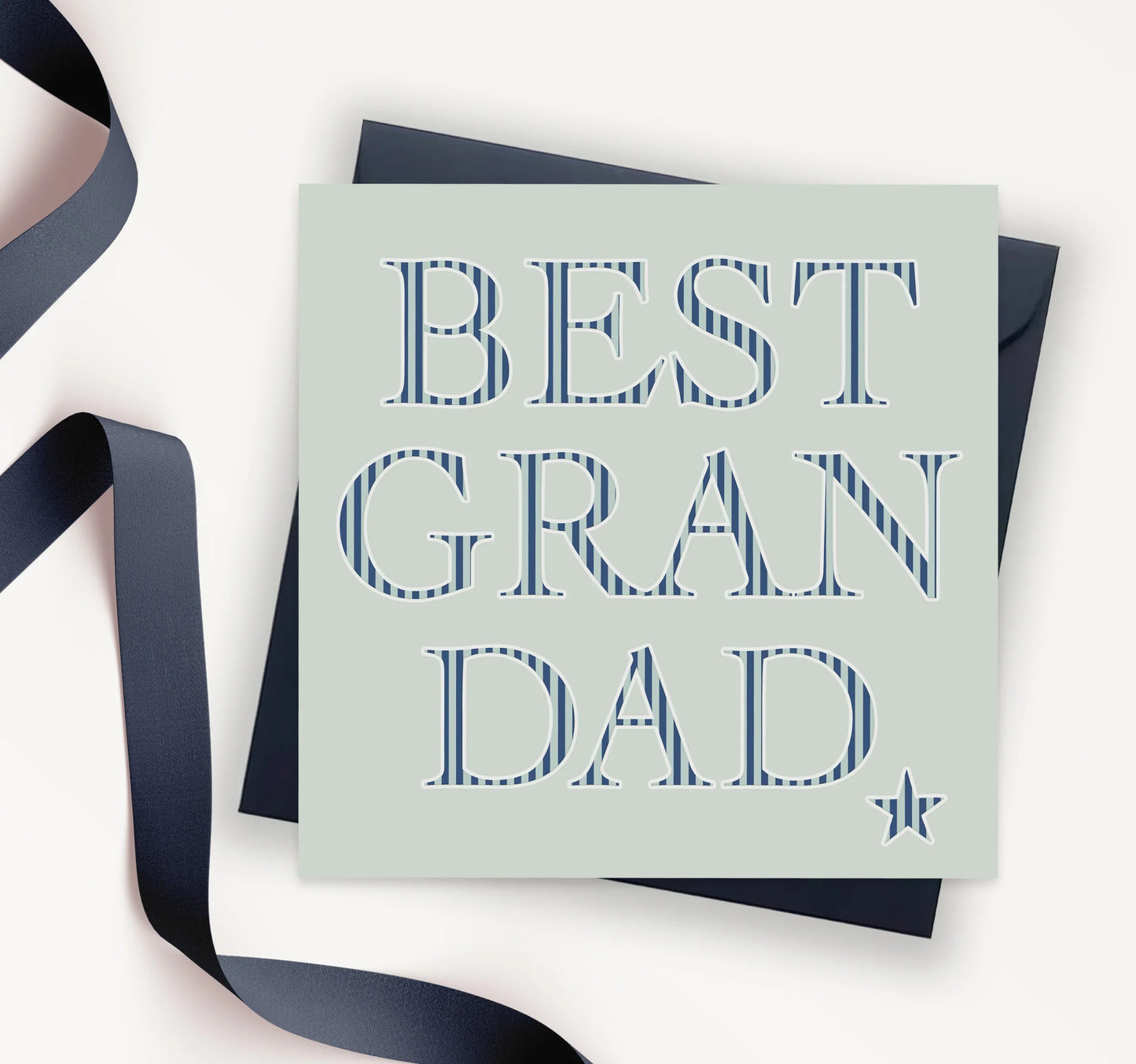 Best Grandad greeting card with blue striped lettering and dark envelope on white background