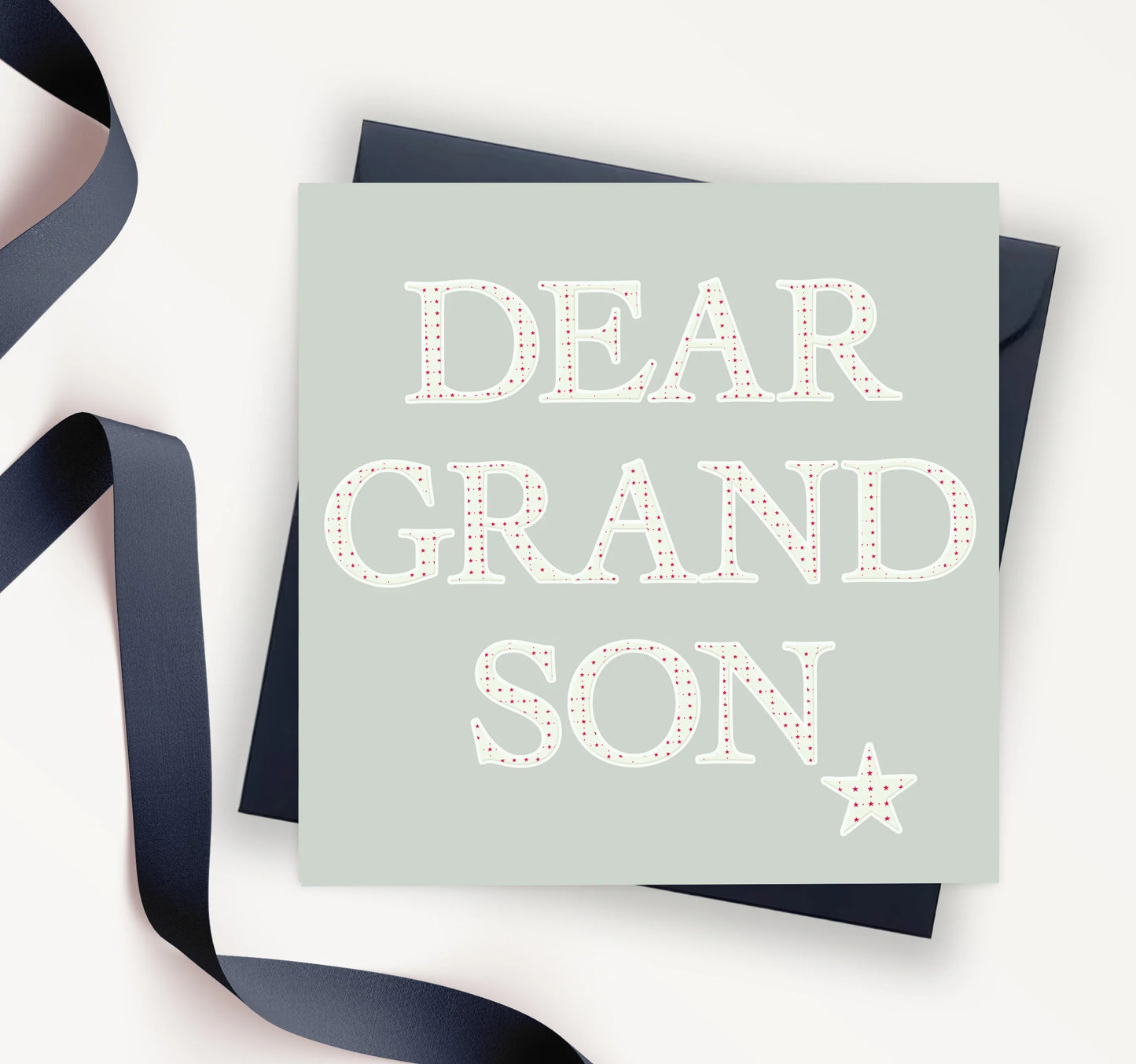 Dear Grandson greeting card with large dotted letters on light background, ribbon and envelope