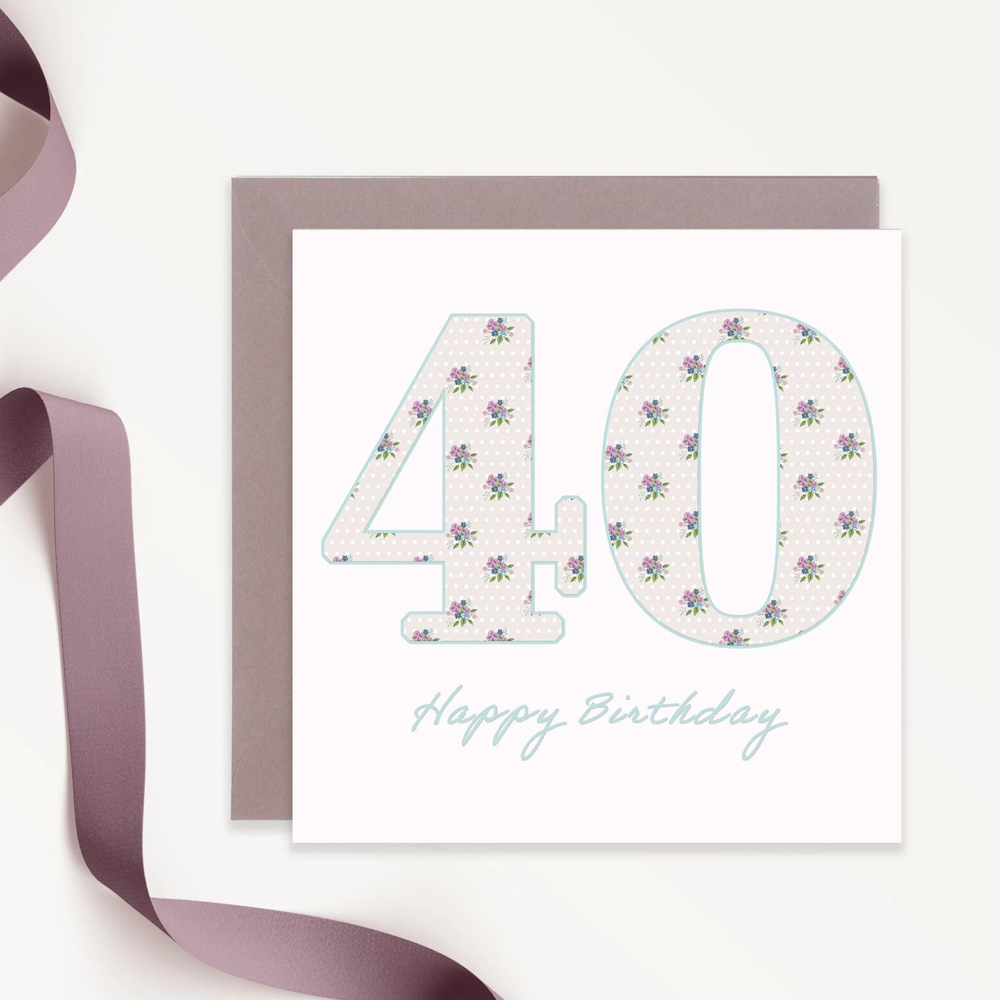 Floral 40th birthday card with pastel flowers and grey envelope, lavender ribbon beside