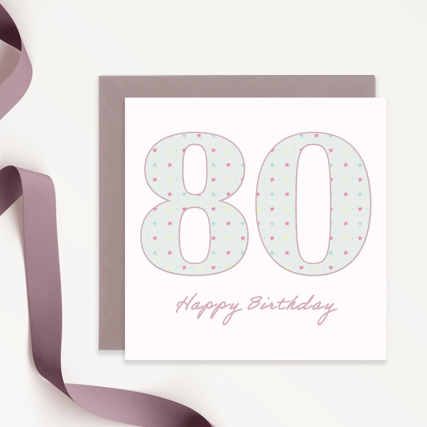 80th birthday card with pastel stars, purple envelope, and ribbon on white background