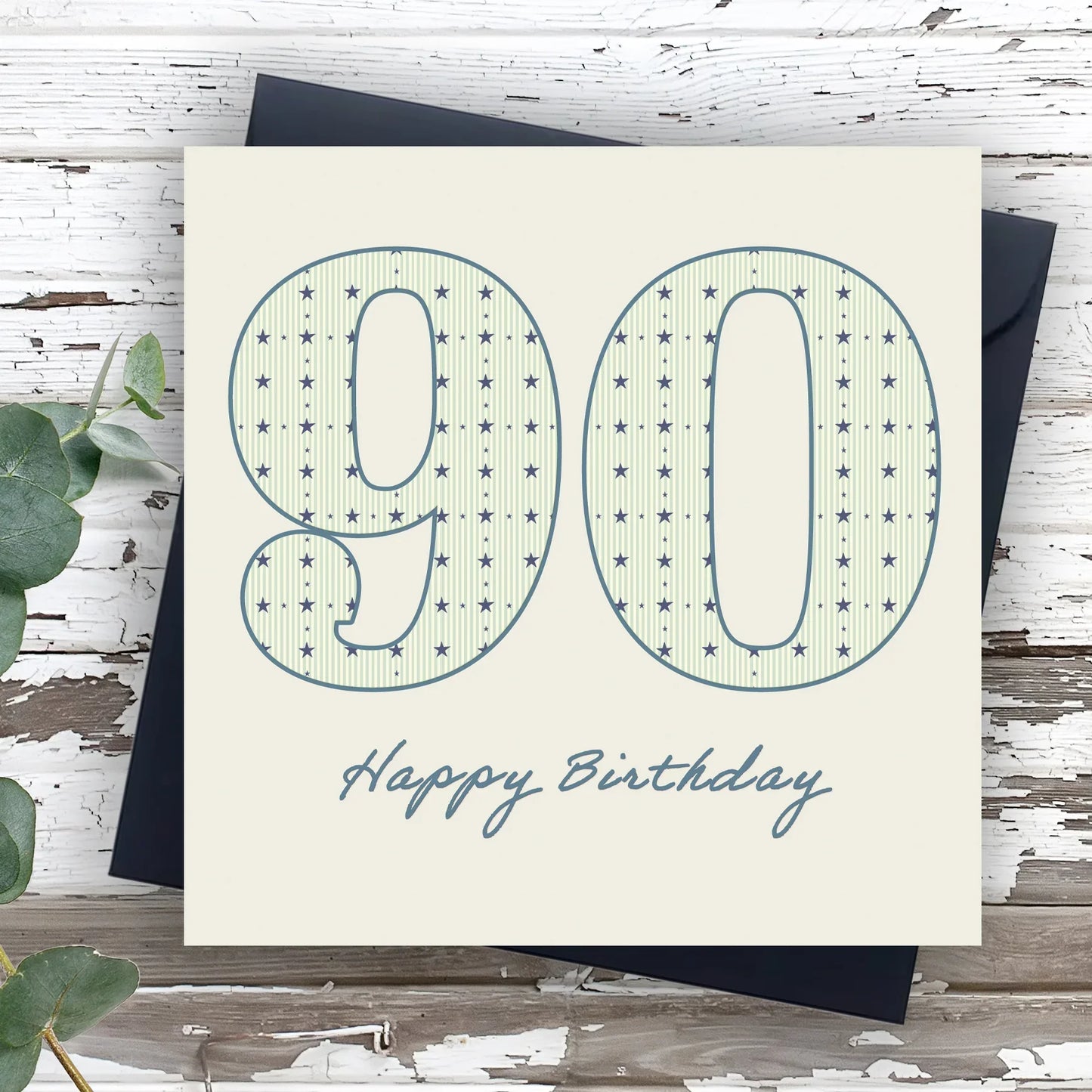 90th birthday card with star pattern and handwritten Happy Birthday text on white wood background