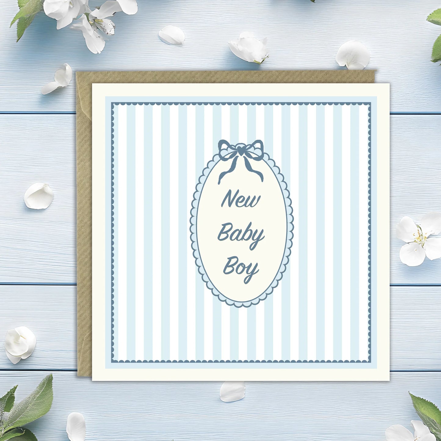 Blue and white striped new baby boy greeting card with bow and floral border on wooden background