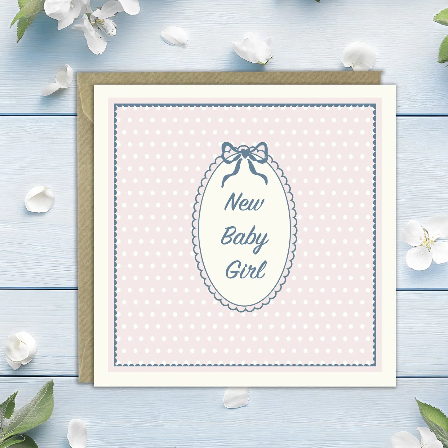 New baby girl greeting card with pink polka dots and bow, envelope, floral background