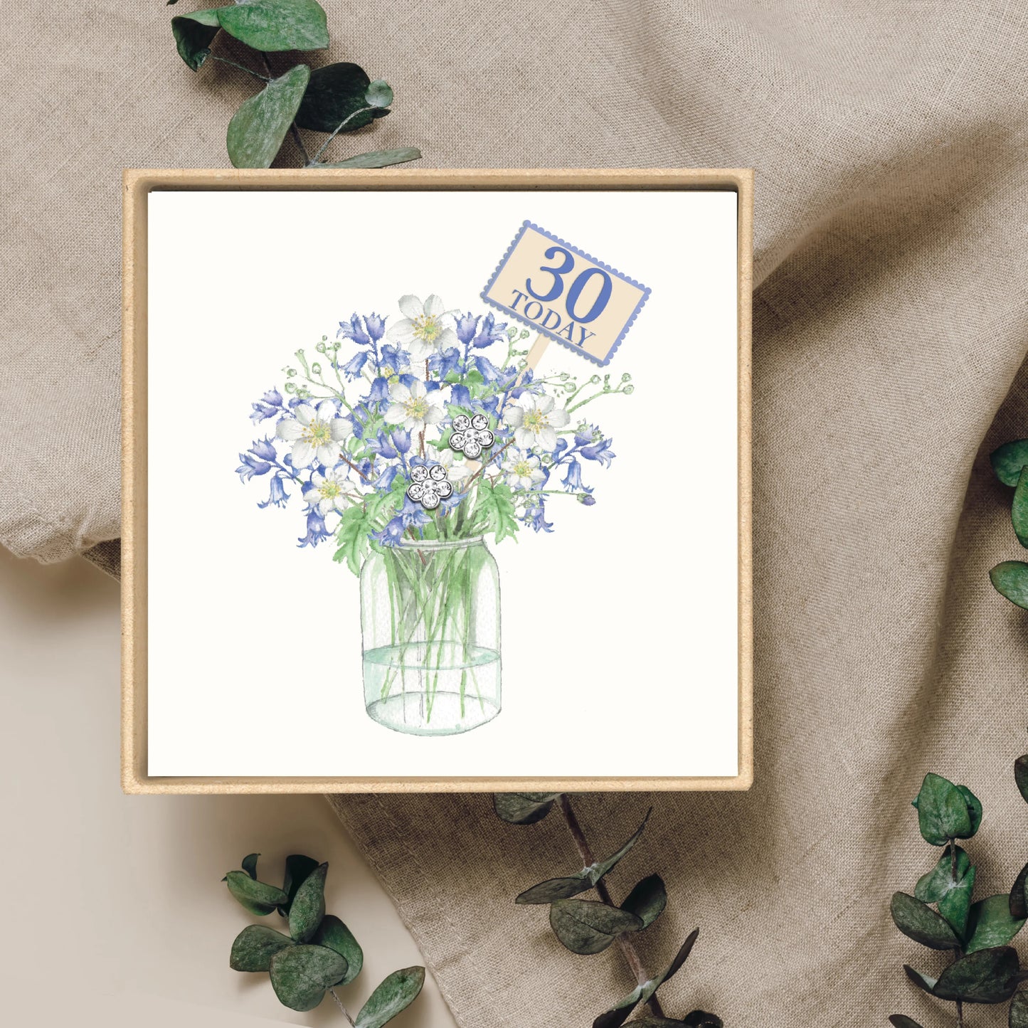 Floral birthday card with blue and white flowers, '30 Today' sign, and silver earrings in a box.