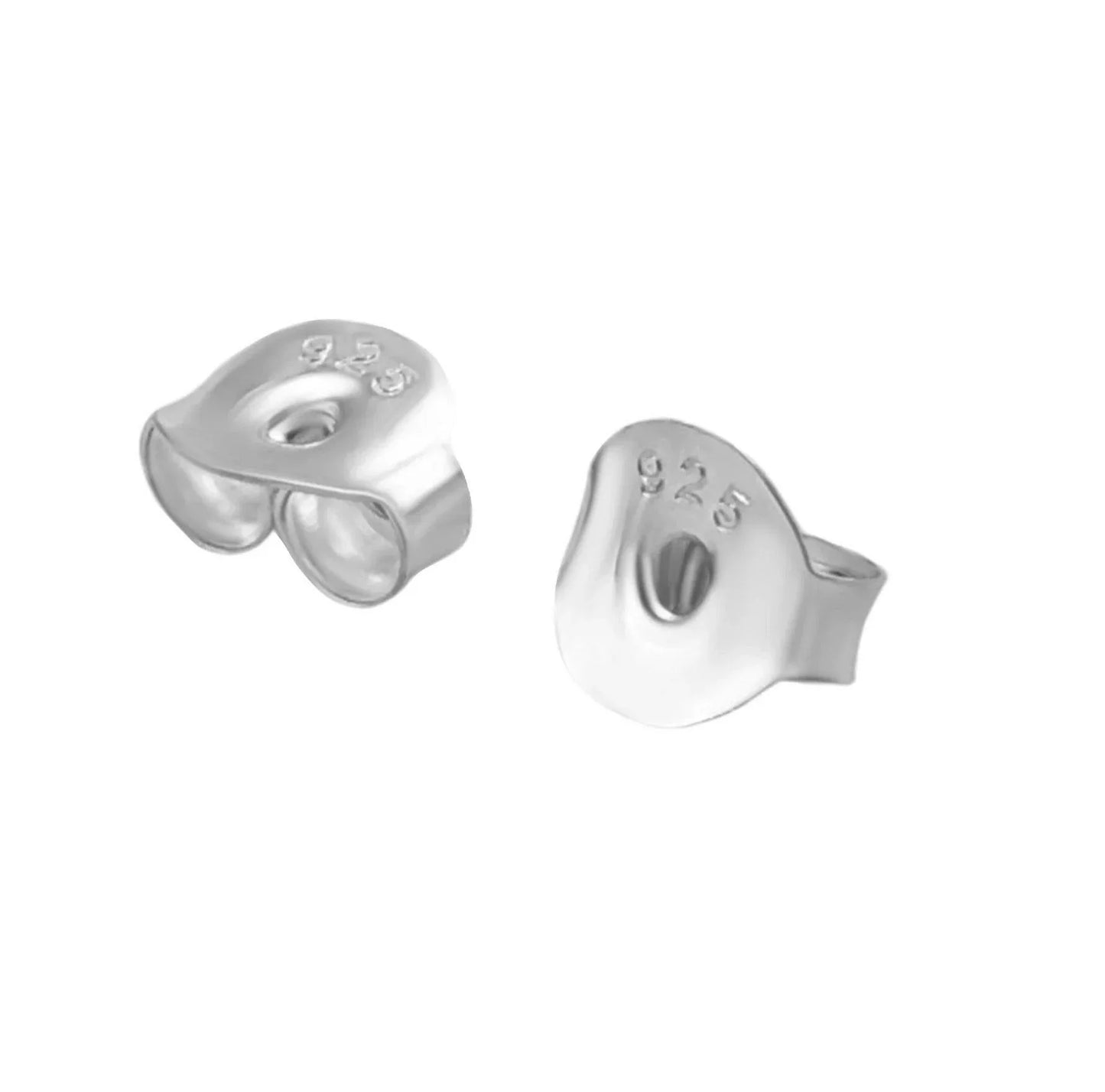 a pair of silver earrings with their earpoches removed, revealing the metal behind.